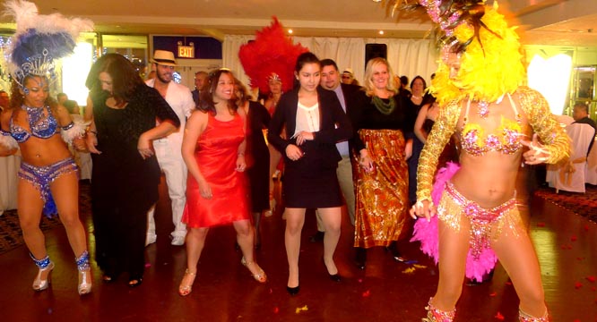 Danielle Lima bailando samba con algunos de los invitados a la fiesta de la HCCQ. 
