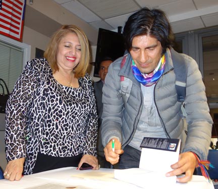 El autor Carlos Pérez Guartambel, firmando su libro Justicia Indígena para entregárselo a la jueza Velásquez.