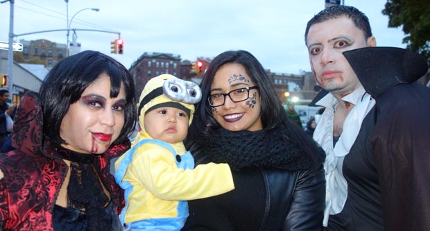 El niño Jeremiah Valle, en los brazos de su madre Laura y rodeado de vampiros en la avenida 37 de Jackson Heights, Queens.  Fotos Javier Castaño