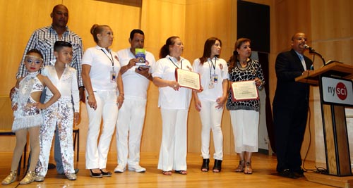 Carlos Plaza, frente al micrófono, quien entregó diplomas a las personas que lo ayudaron a realizar este evento de Independencia de Colombia.