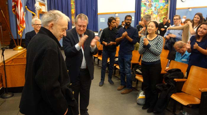 En la PS 69, el concejal Dromm aplaudiendo al documentalista Frederick Wiseman frente al público.