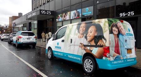 Dos furgonetas de Fidelis Care frente a las nuevas oficinas en Queens Boulevard.