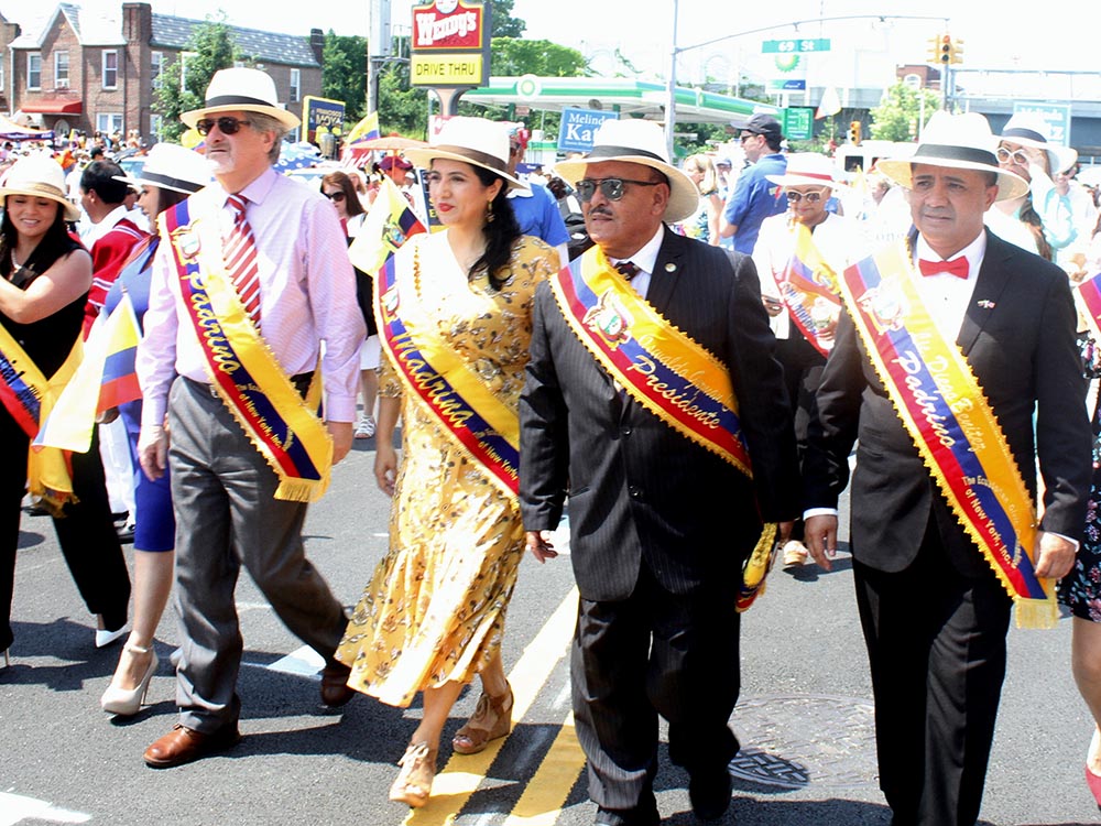 Oswaldo Guzmán, de gafas oscuras, desfilando en compañía de representantes del cuerpo consular de Ecuador.